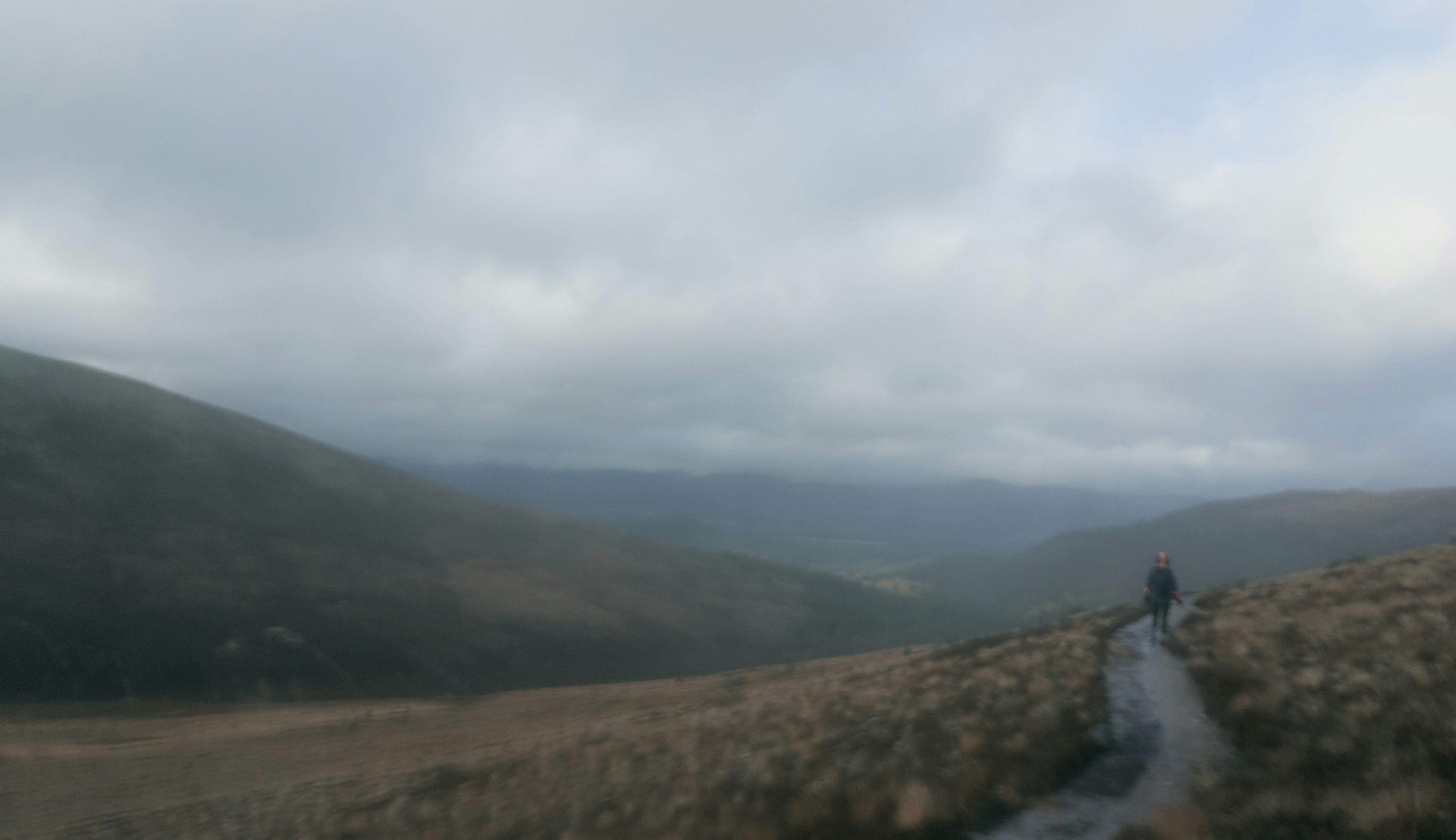 a person walking on a path in a hilly landscape
