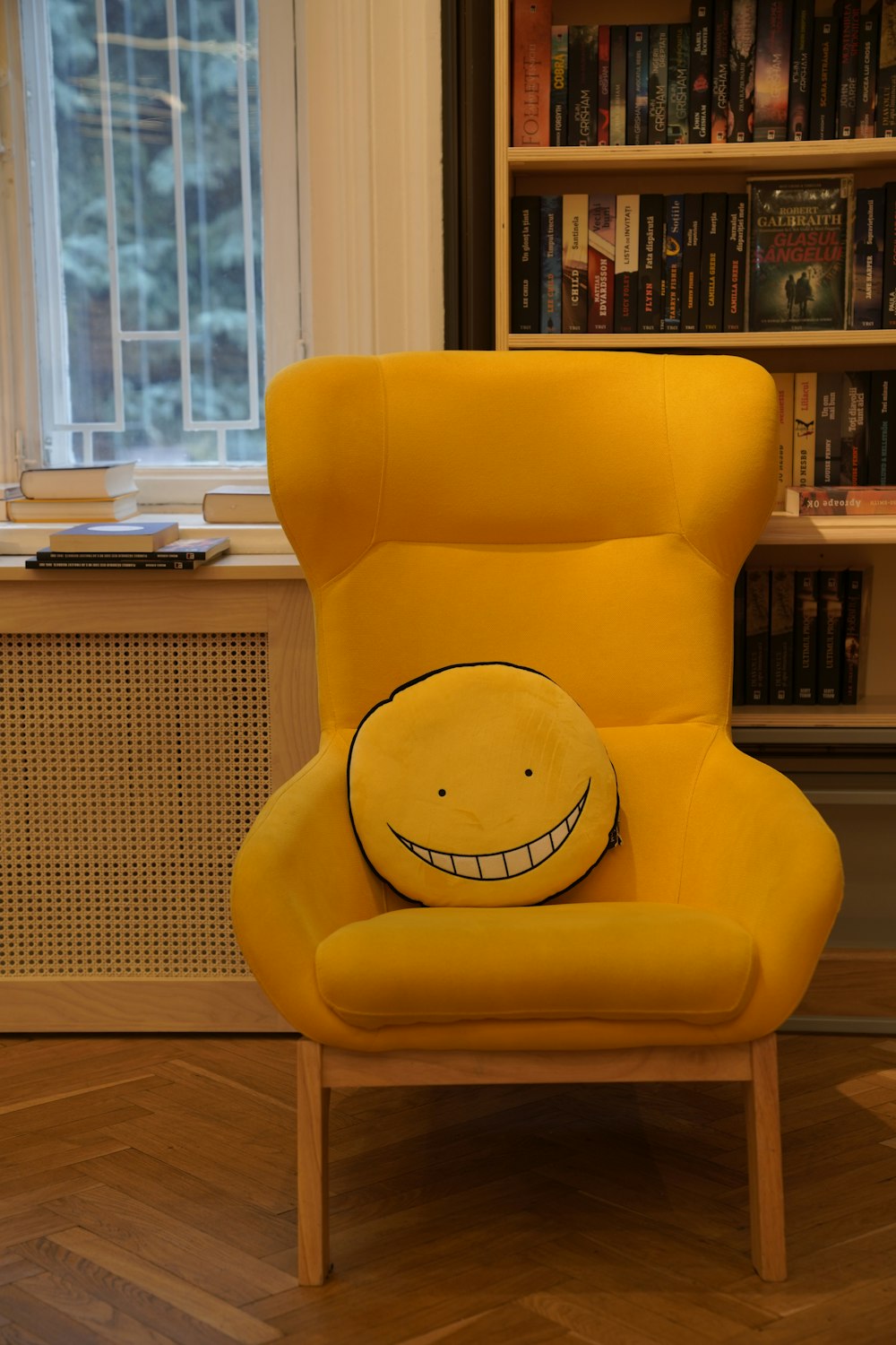 a yellow chair in front of a bookshelf