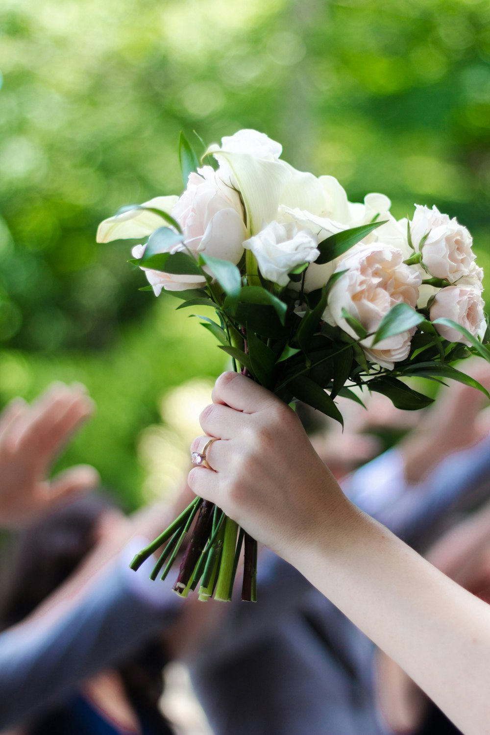 a group of hands holding white flowers