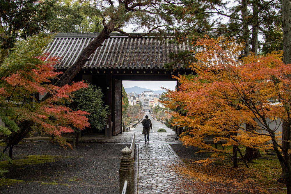 a person walking on a path next to a building with a large archway