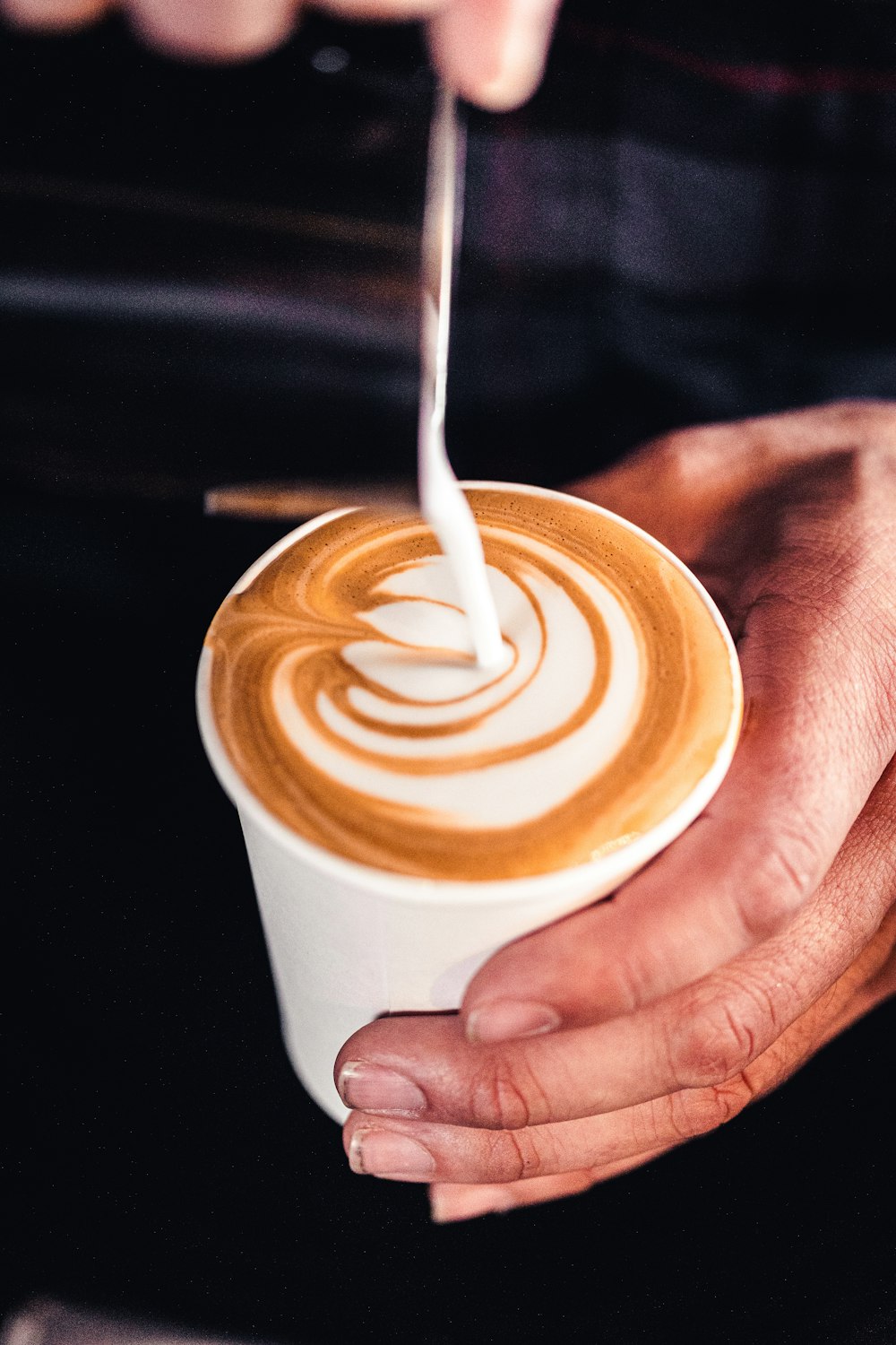 una mano sosteniendo una taza de café