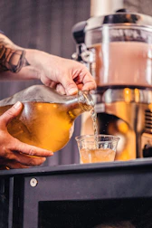 A customer filling a large jug with clear water from the vending machine spout.