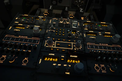 An array of flight control switches and buttons illuminated against a dark cockpit background.