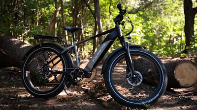 a black bicycle parked in the woods