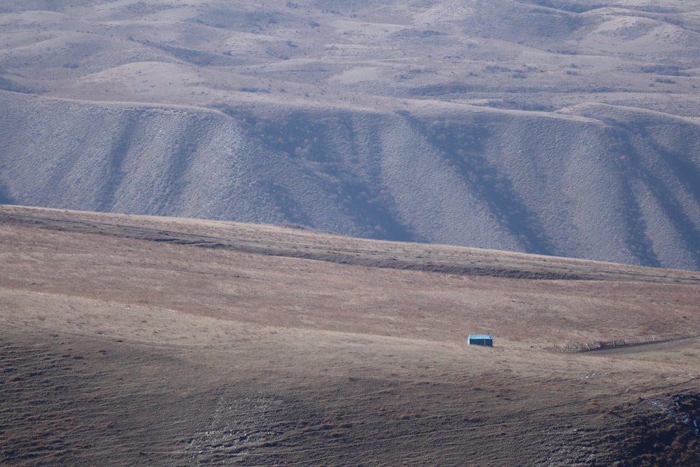 a blue car driving through a desert
