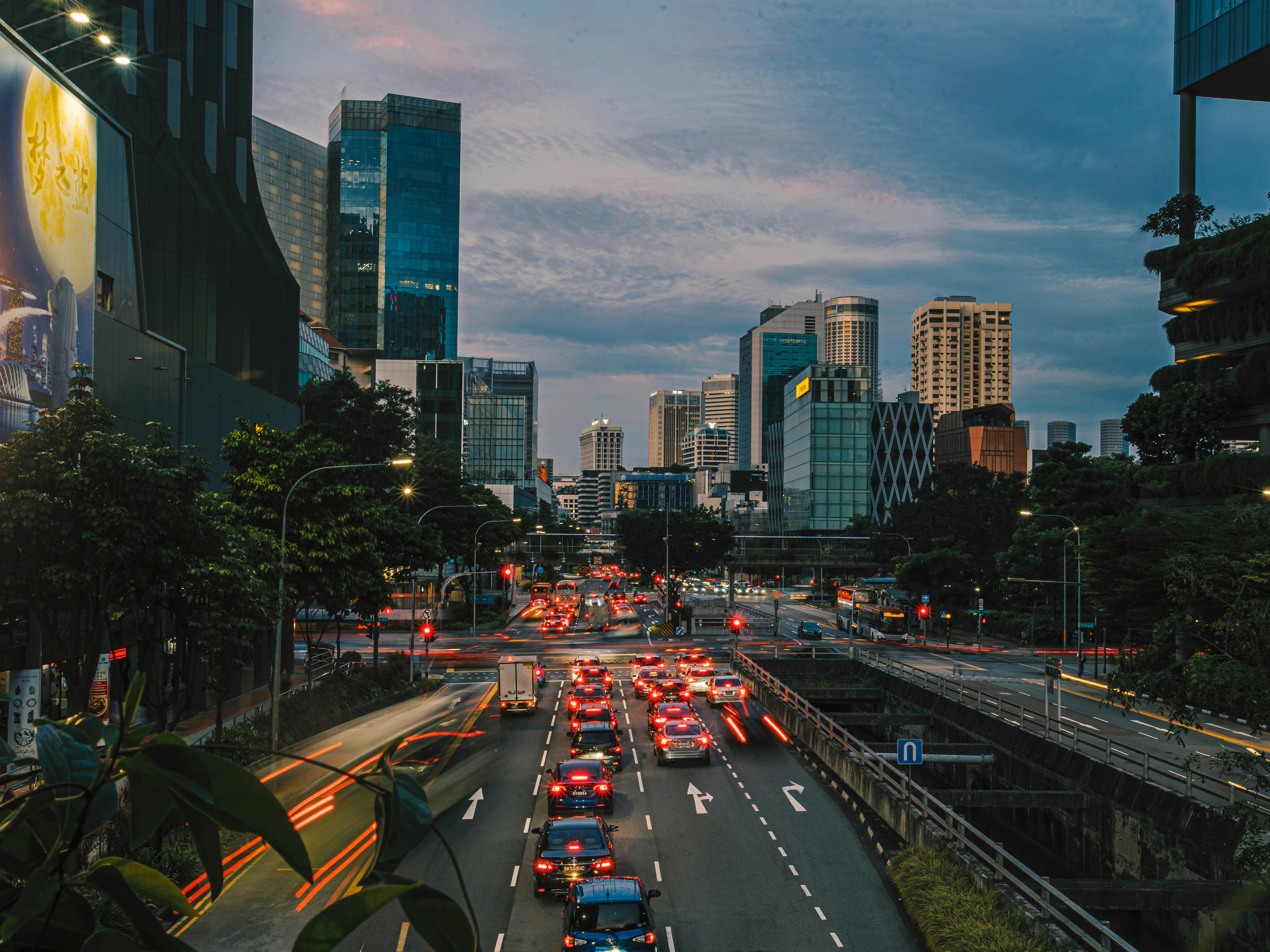 a busy street in a city, Singapore CIty in the evening