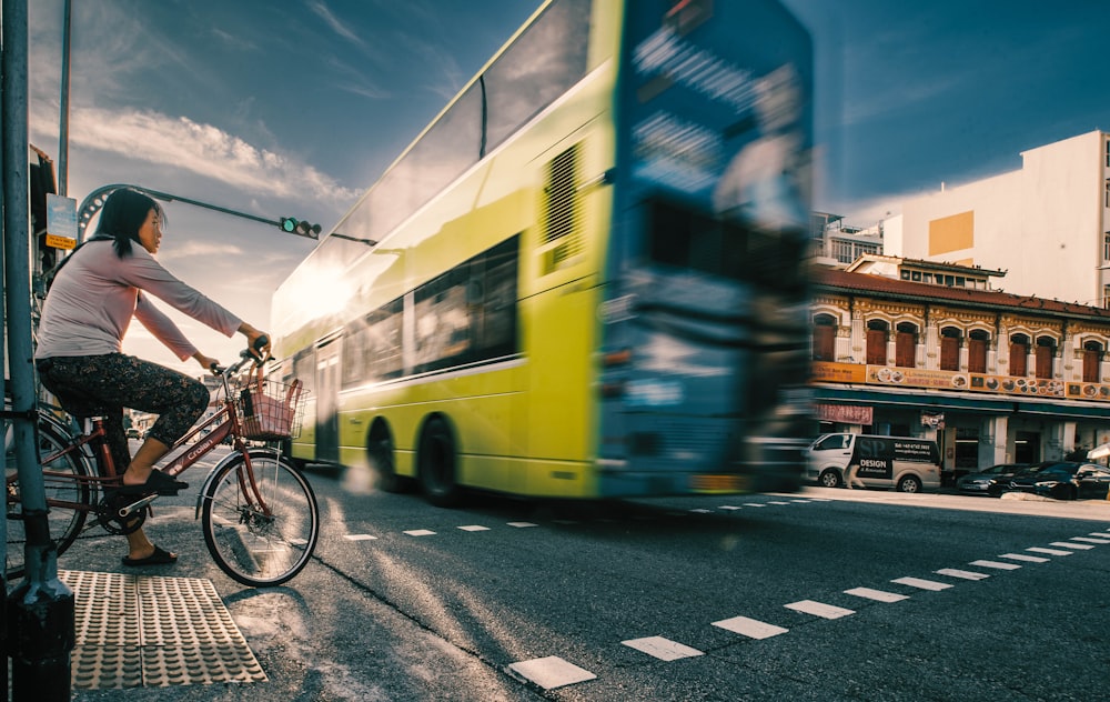 a person riding a bicycle next to a bus