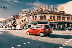 A SpeedParcel delivery van speeding through Kuala Lumpur city streets under a clear blue sky