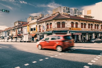 A SpeedParcel delivery van speeding through Kuala Lumpur city streets under a clear blue sky
