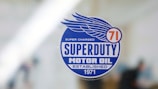 A sticker with a blue circular design features the text 'Superduty Motor Oil' along with the phrases 'Super Charged' and 'Established 1971.' A stylized wing and the number '71' are incorporated into the design.
