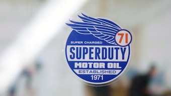 A sticker with a blue circular design features the text 'Superduty Motor Oil' along with the phrases 'Super Charged' and 'Established 1971.' A stylized wing and the number '71' are incorporated into the design.