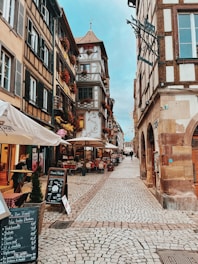 Charming cobblestone street in a European old town with colorful buildings and outdoor cafes.