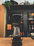 A modern open box coffee maker displayed on a kitchen counter with natural morning light.