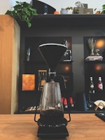 An elegant kitchen gadget, like a modern coffee maker, with fresh coffee being poured.