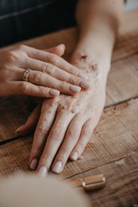 a person's hands on a wooden surface