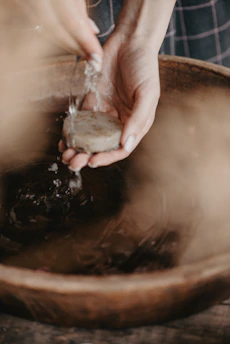 Close-up of a hand gently squeezing true tides hand soap onto palm with soft natural light.
