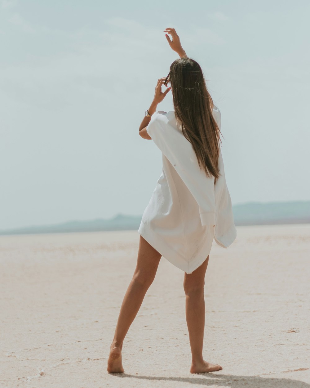 a woman in a white dress on a beach