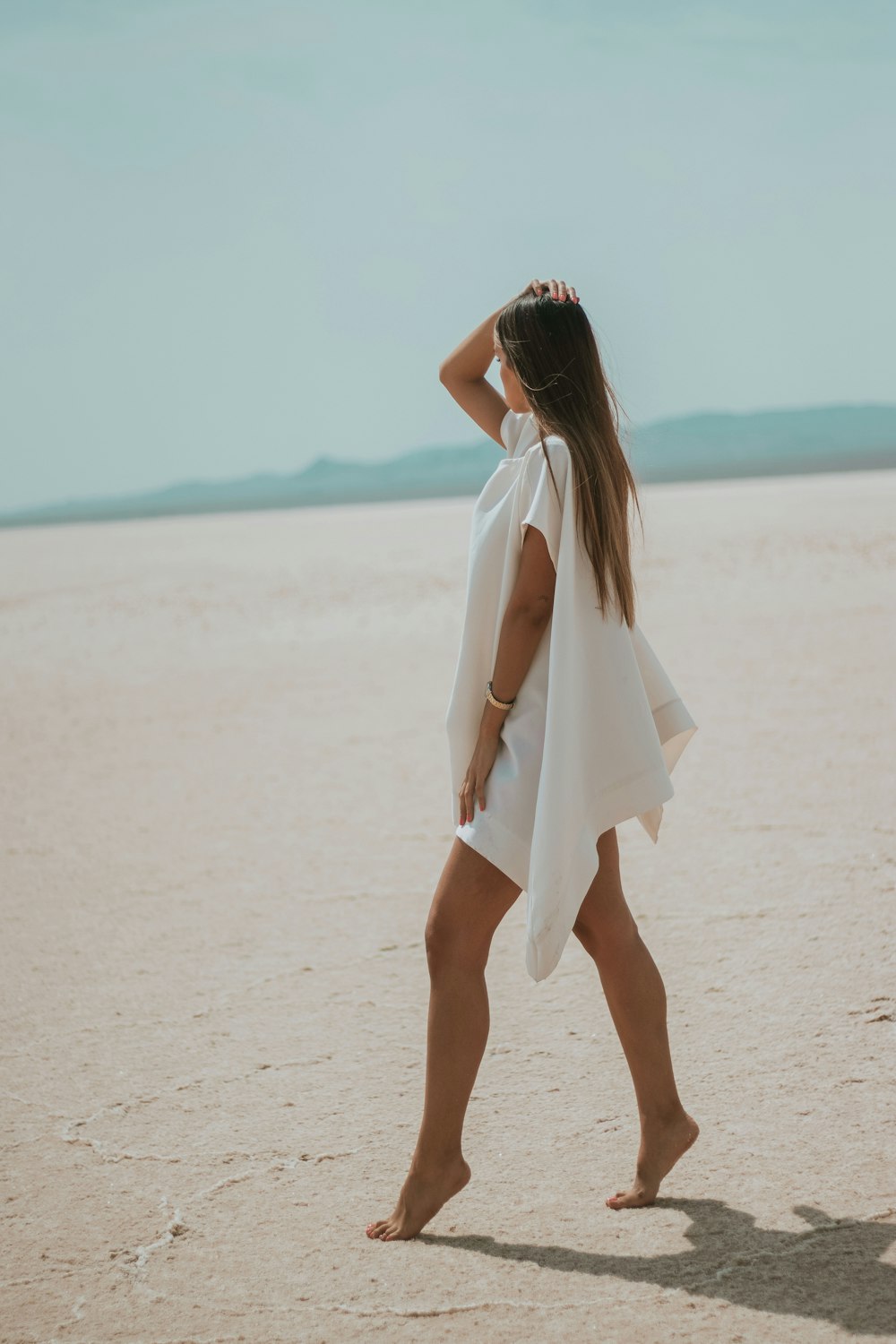 a woman in a white dress on a beach