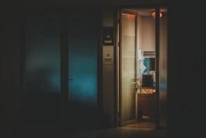 A professional legal consultant reviewing confidential documents in a sleek office with dark blue and grey tones.