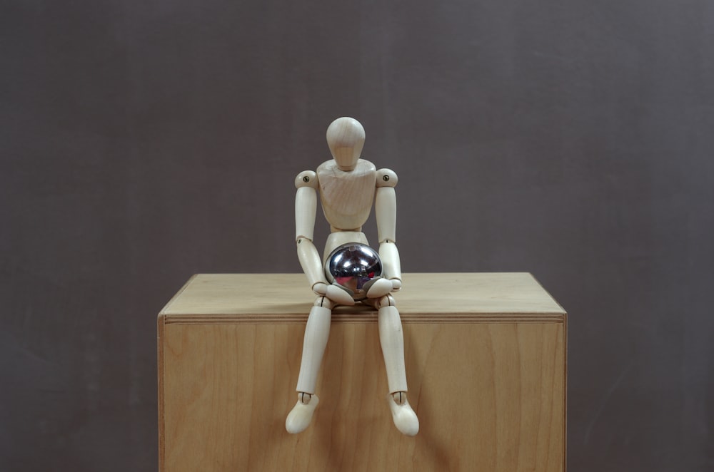 a white toy on a wooden shelf