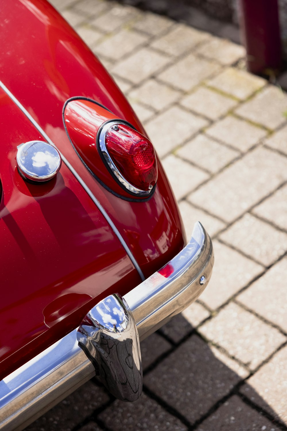 a red car parked on a brick road