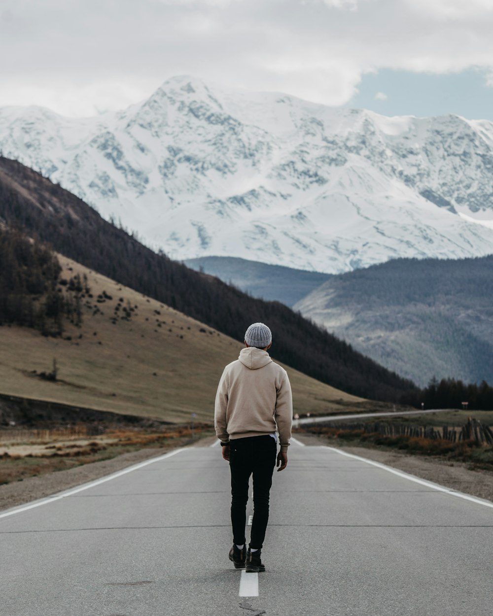 a person walking on a road with a mountain in the background