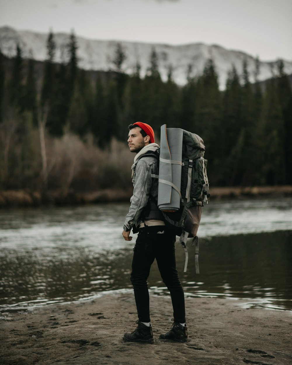 a man with a backpack walking on a beach