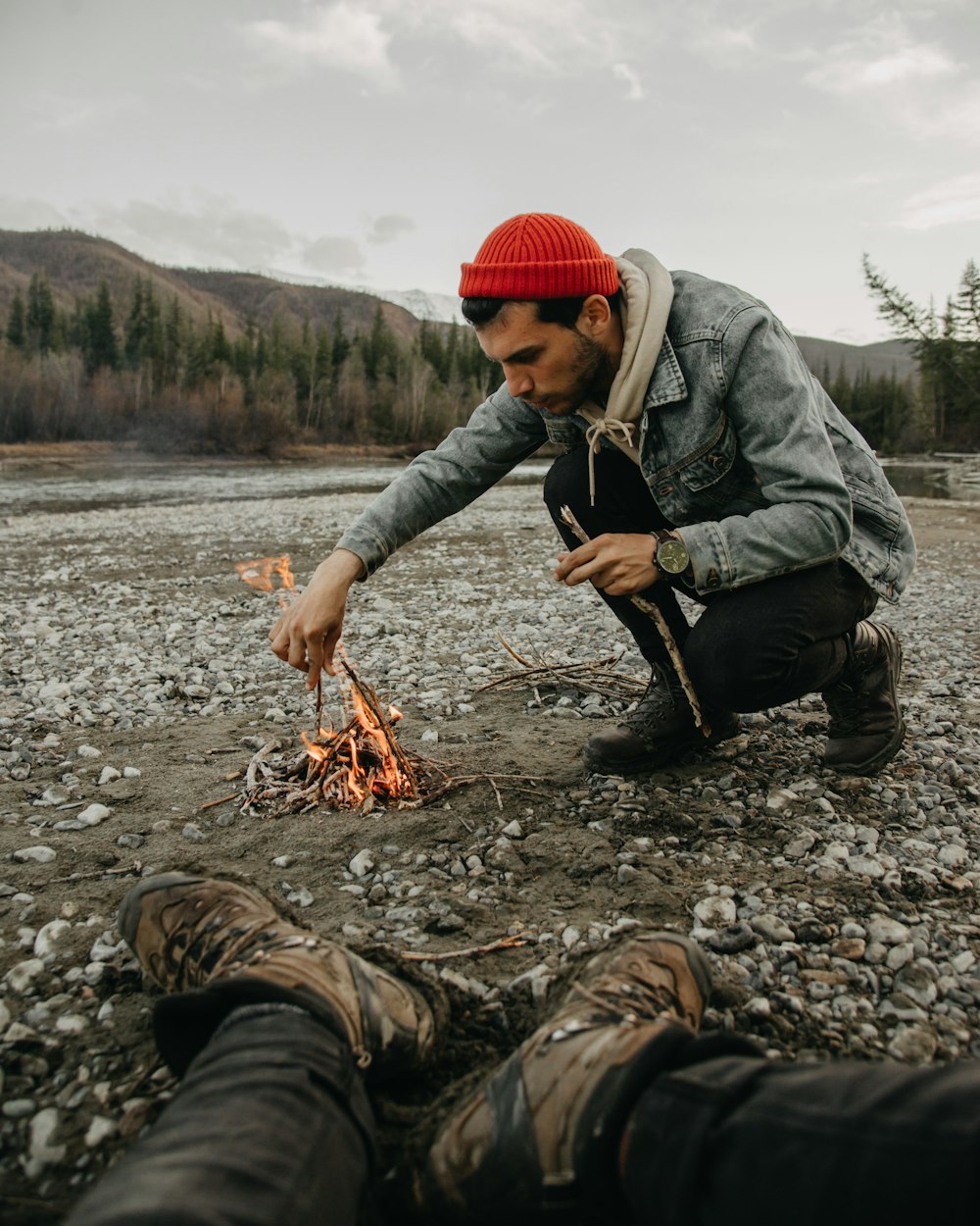 a man kneeling over a fire