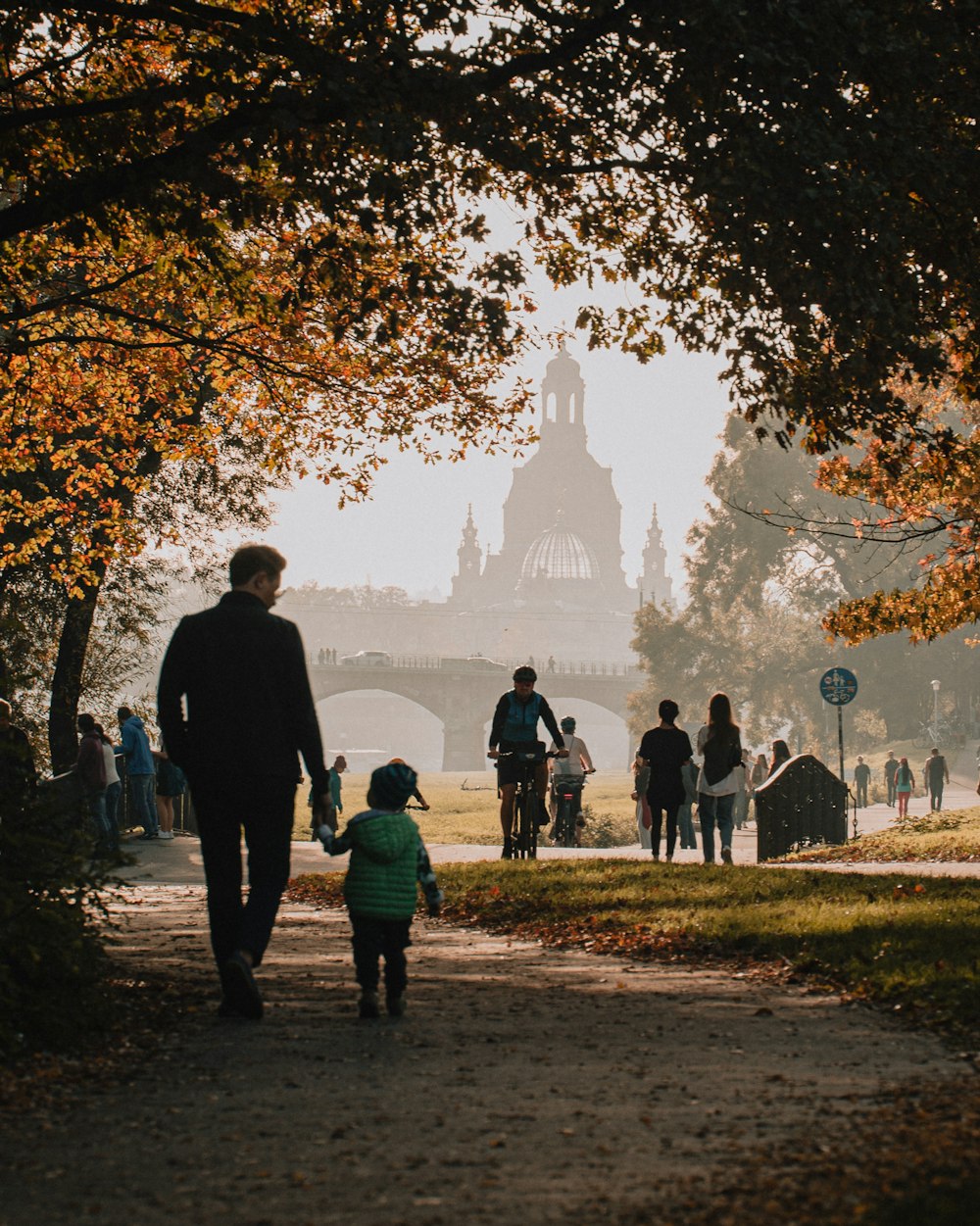 a group of people walking on a path with a castle in the background