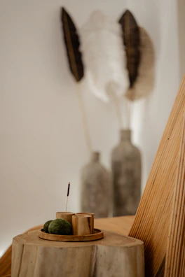 a wall with a painting and a vase with a plant in it