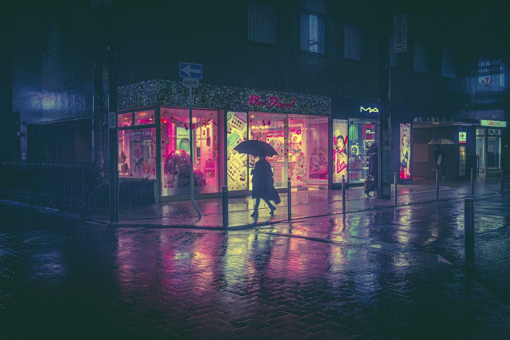Eine Person, die mit einem Regenschirm im Regen spazieren geht