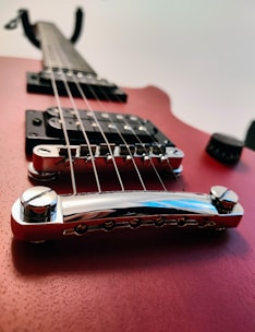 Fender electric guitar with vibrant red finish and chrome hardware, angled against a dark background.