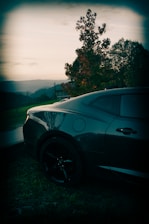 A stylish car parked against a scenic backdrop.