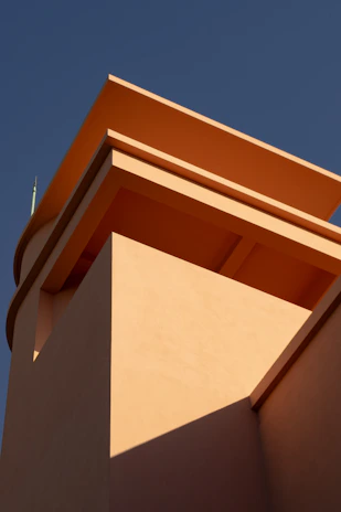 A striking architectural detail of a modern building with muted earth tone accents and sharp angles.