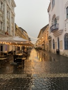 a wet street with tables and chairs
