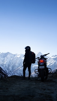 a man standing next to a motorcycle