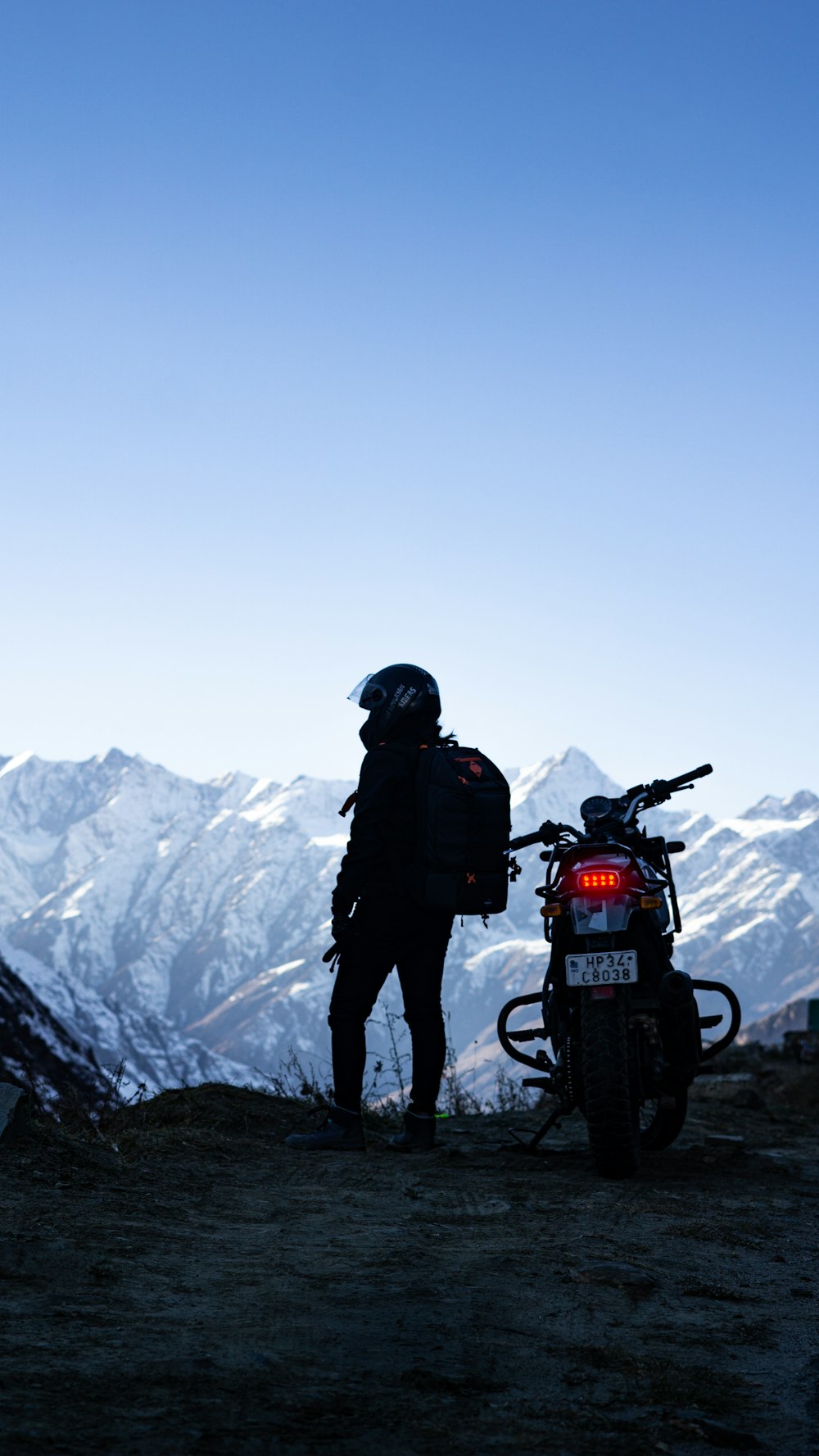 a man standing next to a motorcycle