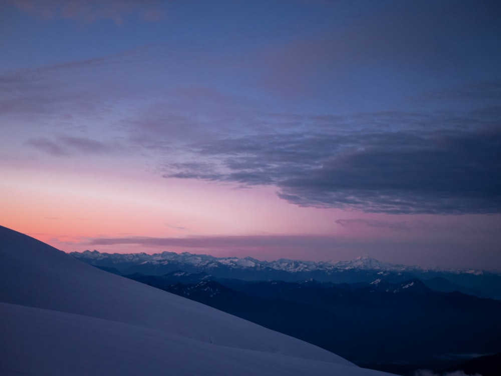 a landscape with mountains and a sunset