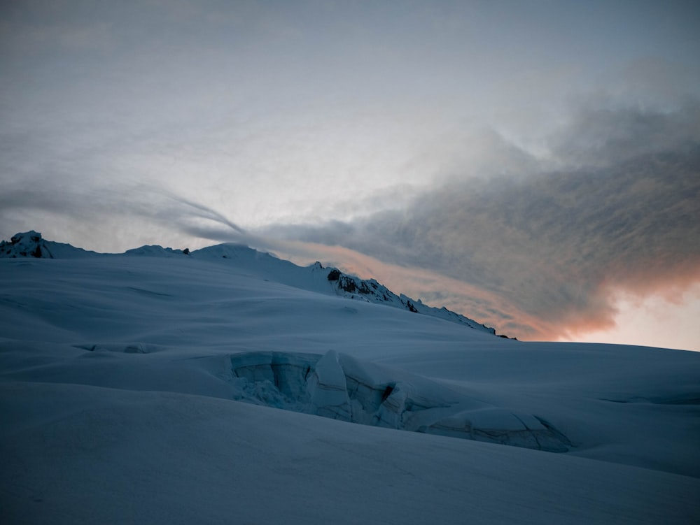 a snowy mountain with a sunset