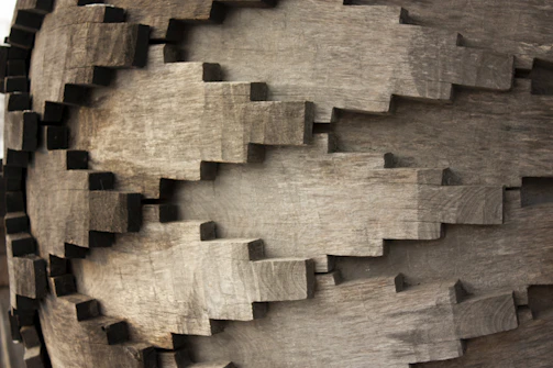 Close-up of a sleek 3D printed gear with intricate details, resting on a wooden workbench.