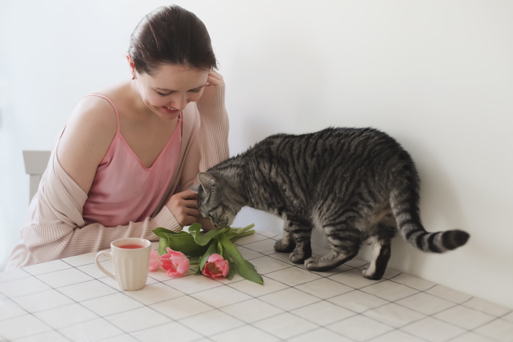 a woman feeding a cat