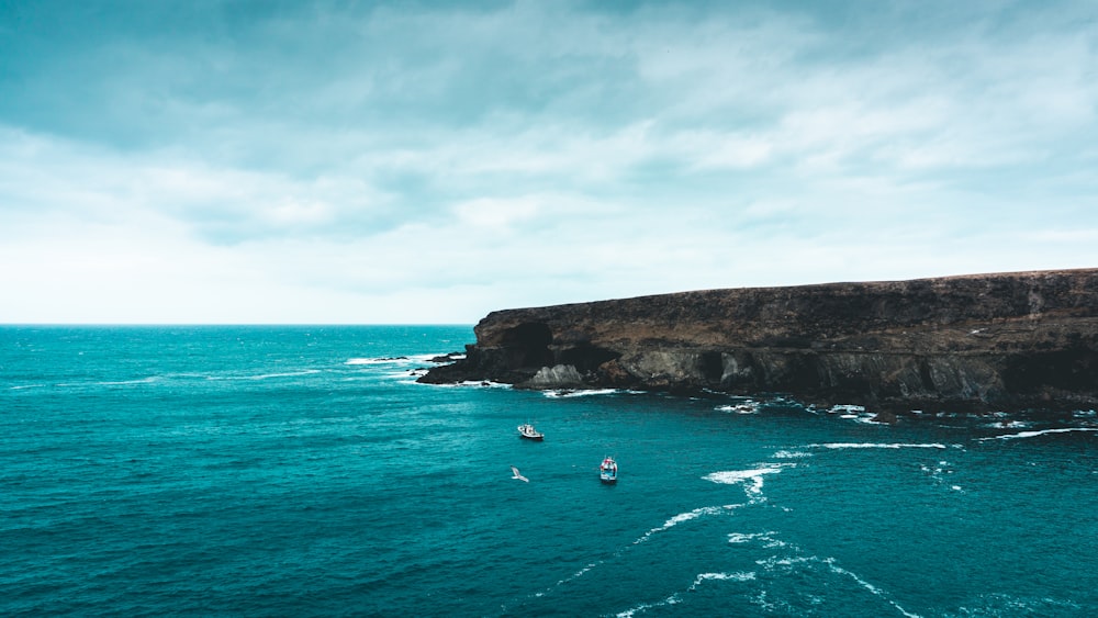 a rocky cliff next to a body of water