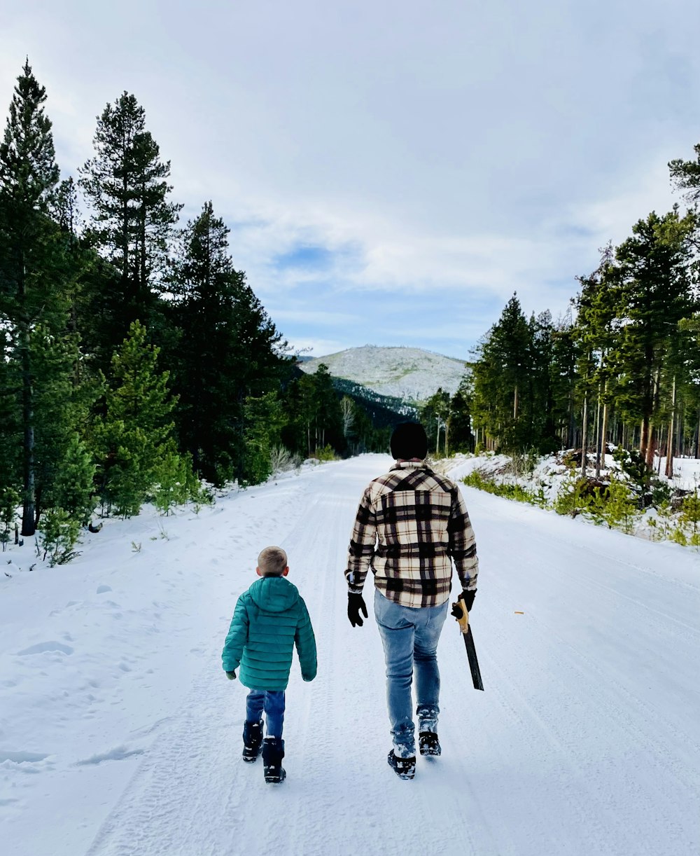 a man and a child walking on a snowy road