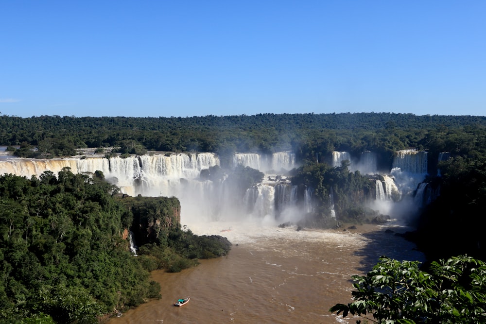 a large waterfall with trees around it