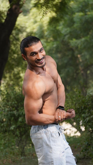 A male model showcasing casual wear with a relaxed smile in natural light