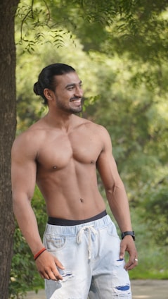 A man confidently wearing a Korpa t-shirt outdoors, smiling and relaxed.