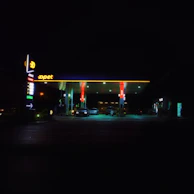 Night shot of a petrol storage facility illuminated with safety lights.