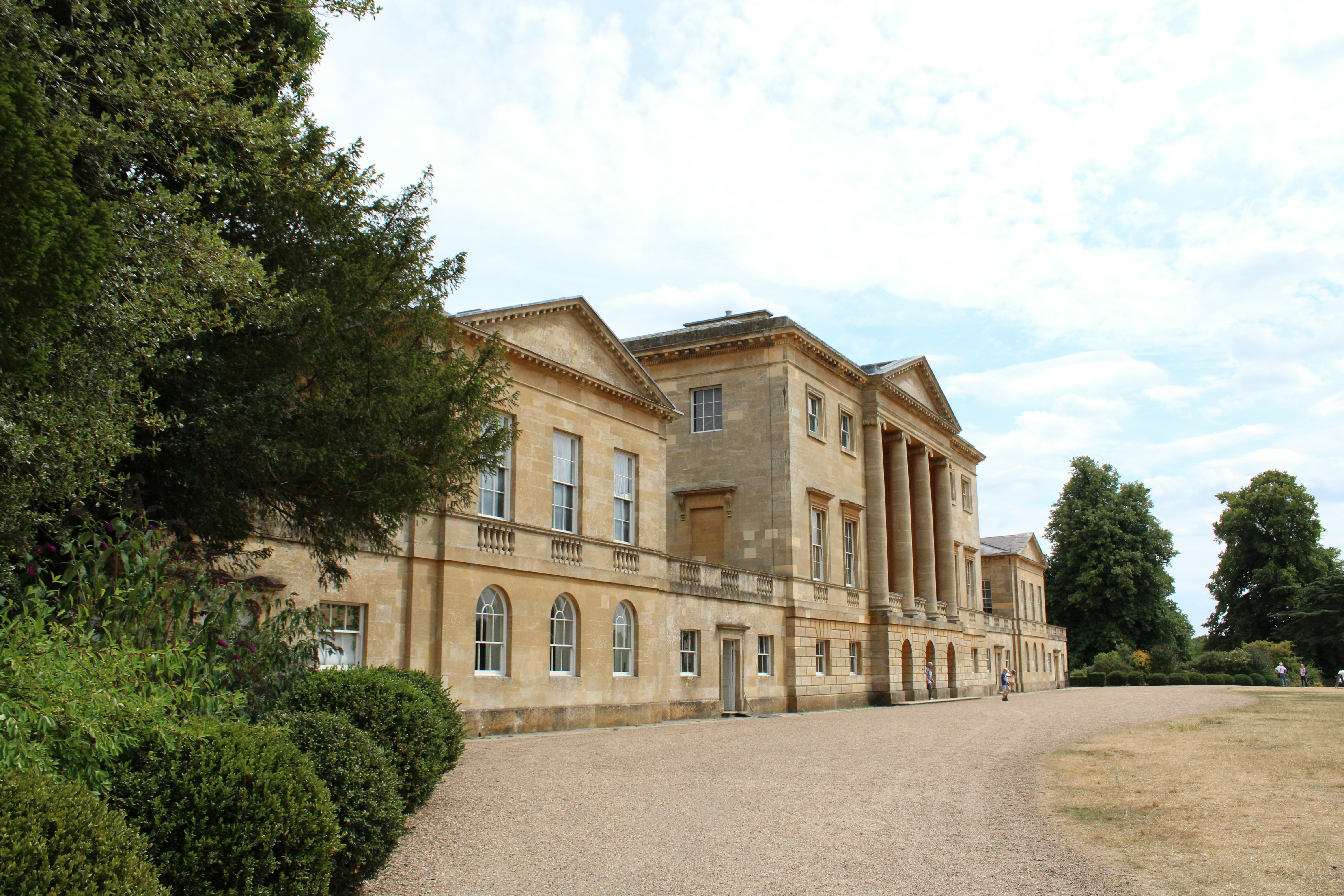 a large building with trees in front of it with Basildon Park in the background