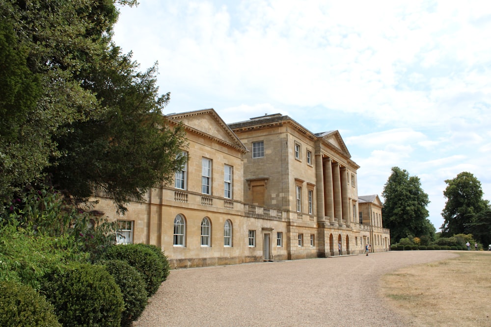 a large building with trees in front of it with Basildon Park in the background