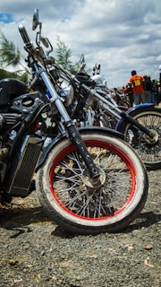 A group of diverse motorcycles lined up under a glowing sunset sky